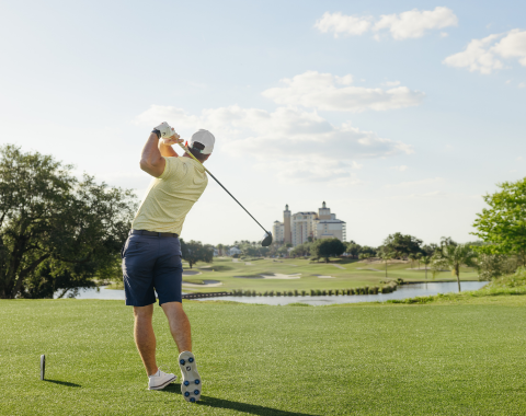 Golfer playing with the Reunion clubhouse in the distance